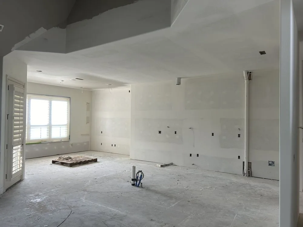Kitchen and living area with a shaped soffit and finished drywall walls, seen from the entry.