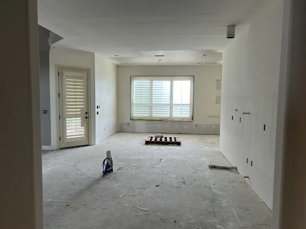Open living and kitchen area with clean, finished drywall on the walls and ceiling before flooring and paint.